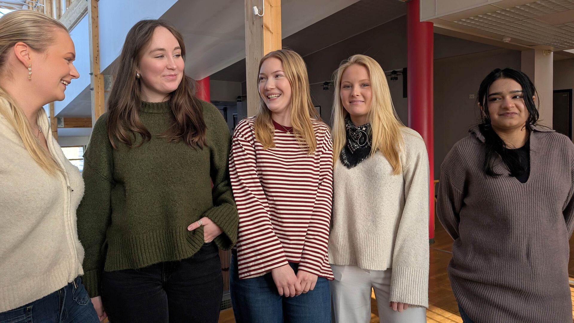 De fem lærlingene oppstilt, prater med hverandre, noen ser i kamera.
