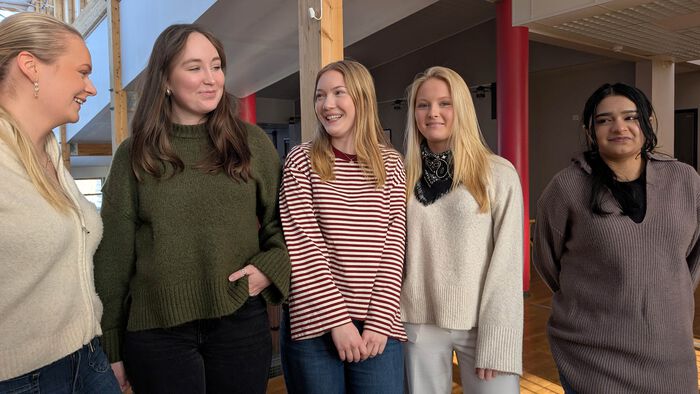 De fem lærlingene oppstilt, prater med hverandre, noen ser i kamera.
