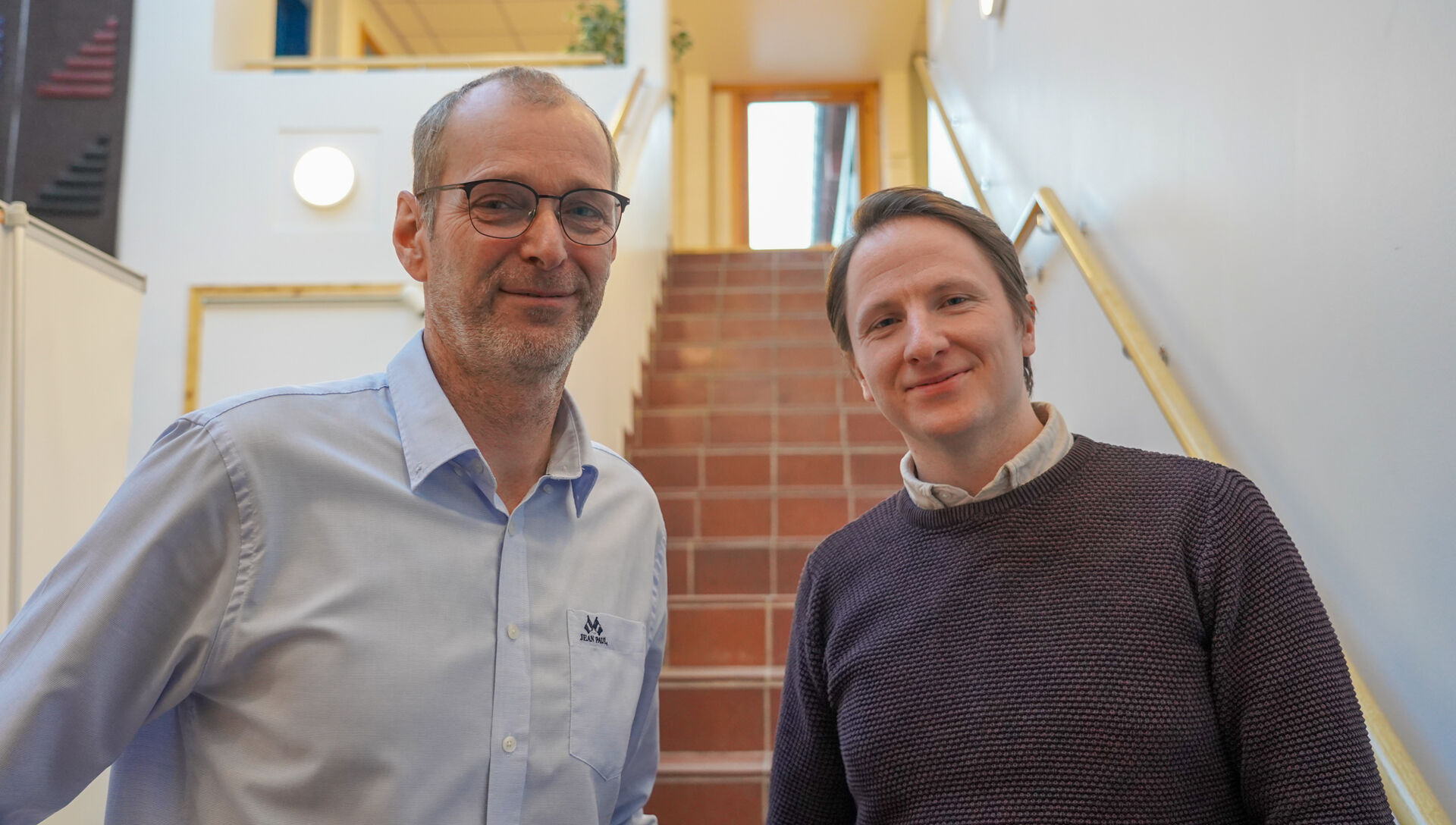 To menn foran en trapp i kommunehuset i Alvdal