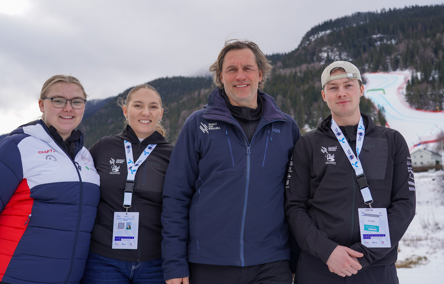 Studentene og sjefen for Kvitfjell-verdenscupen ved siden av hverandre ut med utforbakken i bakgrunnen