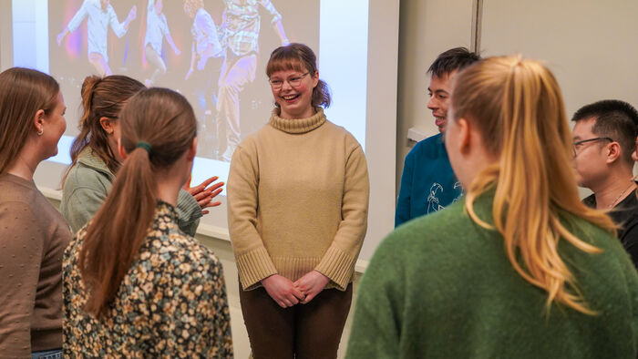 En gjeng studenter står i ring og ler og roper til hverandre