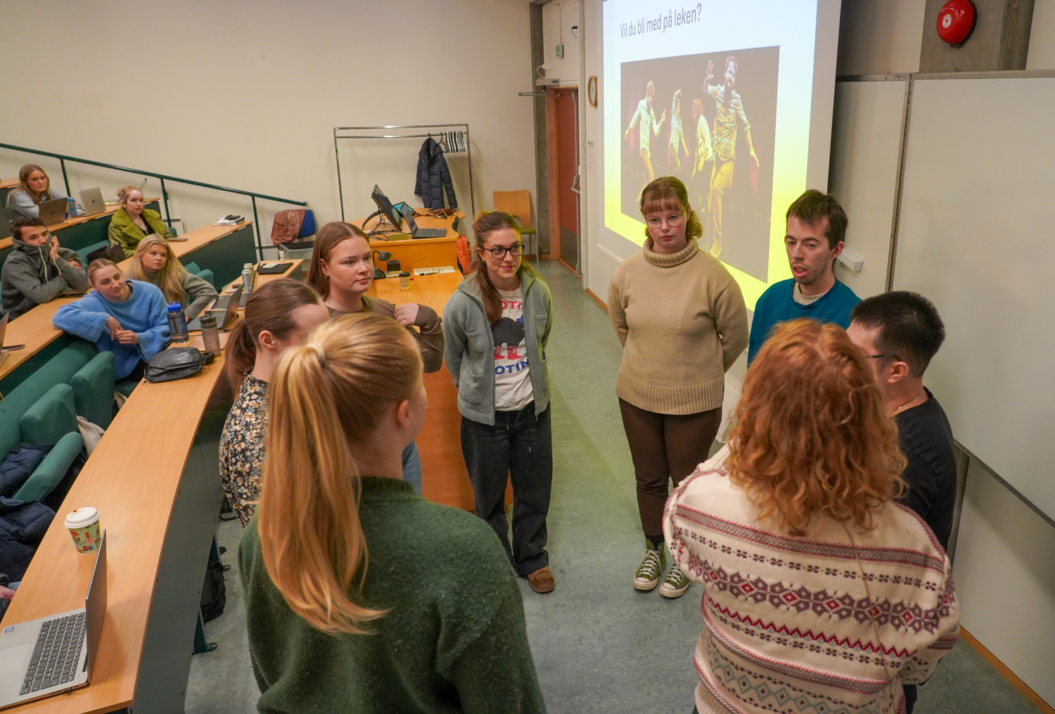 Alvorlige studenter i en ring foran klassen sin i et auditorium