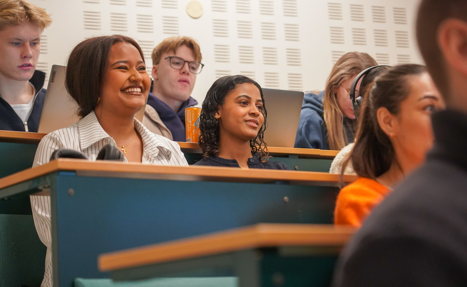 Studenter i et auditorium ler
