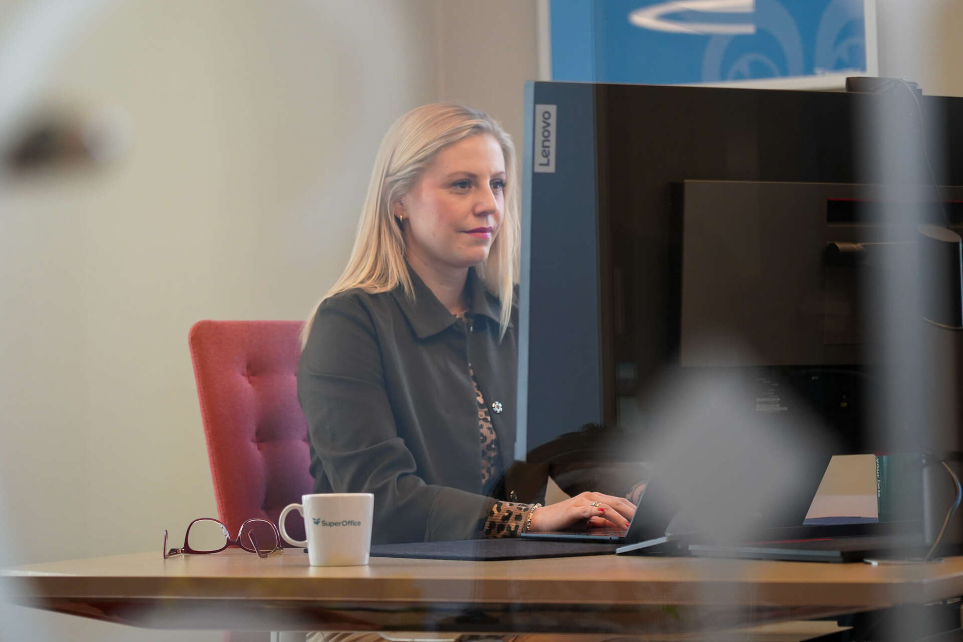 Dame sitter og jobber ved en PC