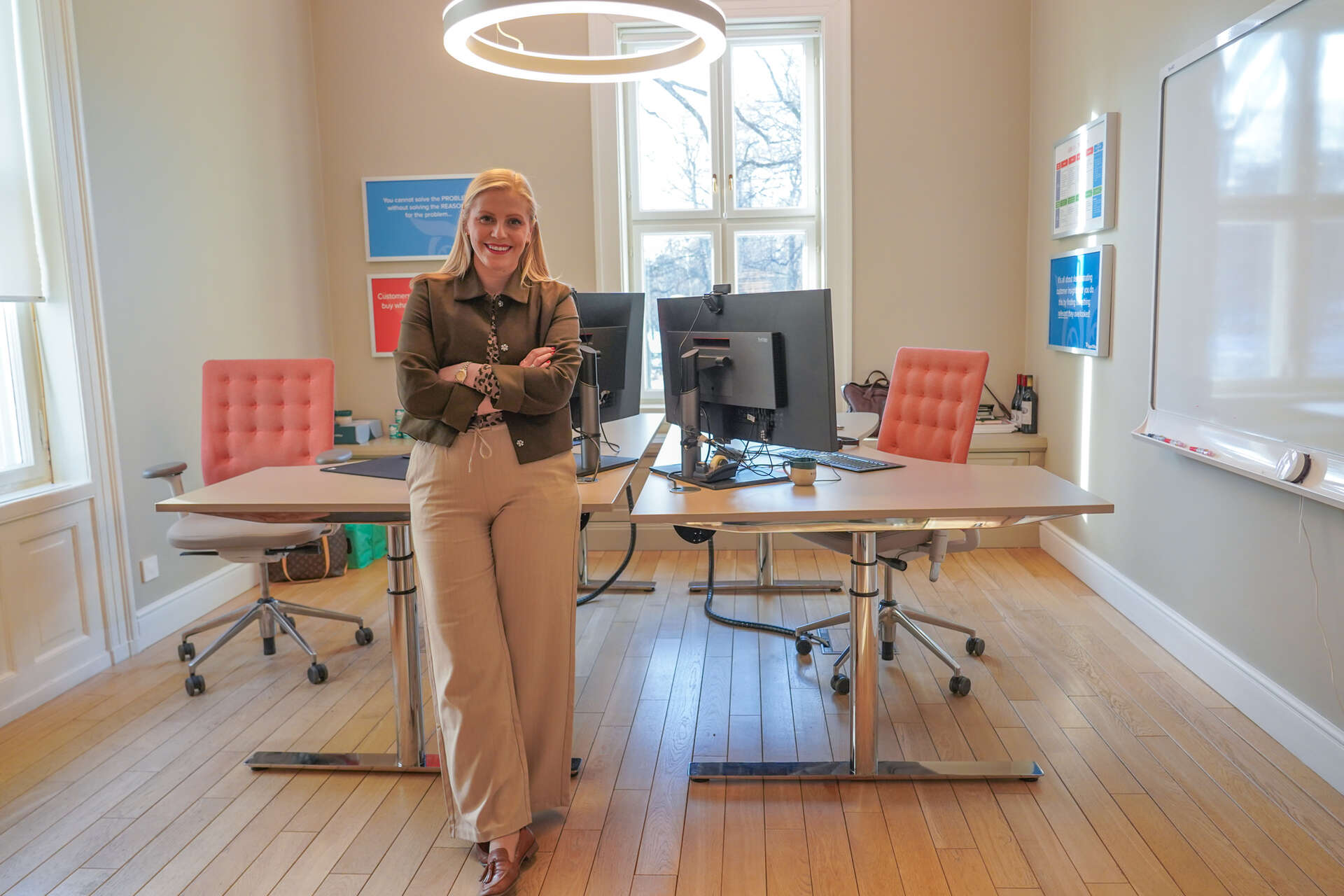 Dame står foran en pult inne på et kontor