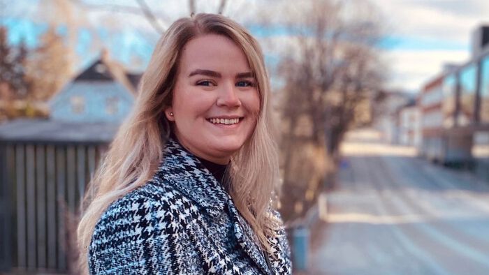 Smilende student utendørs. 