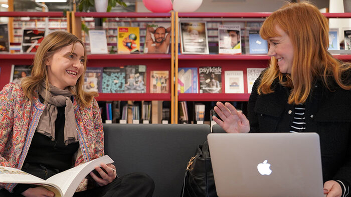 To kvinnelige studenter som jobber på biblioteket. 