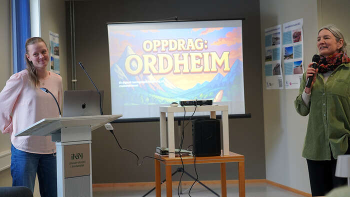 Kvinnelig student foran en PC når hun presenterer en oppgave. 