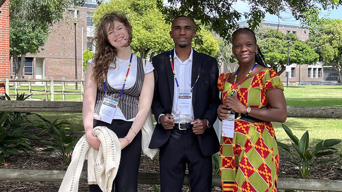 one norwegian and two namibian students at a conference. They are sitting outside in the sun