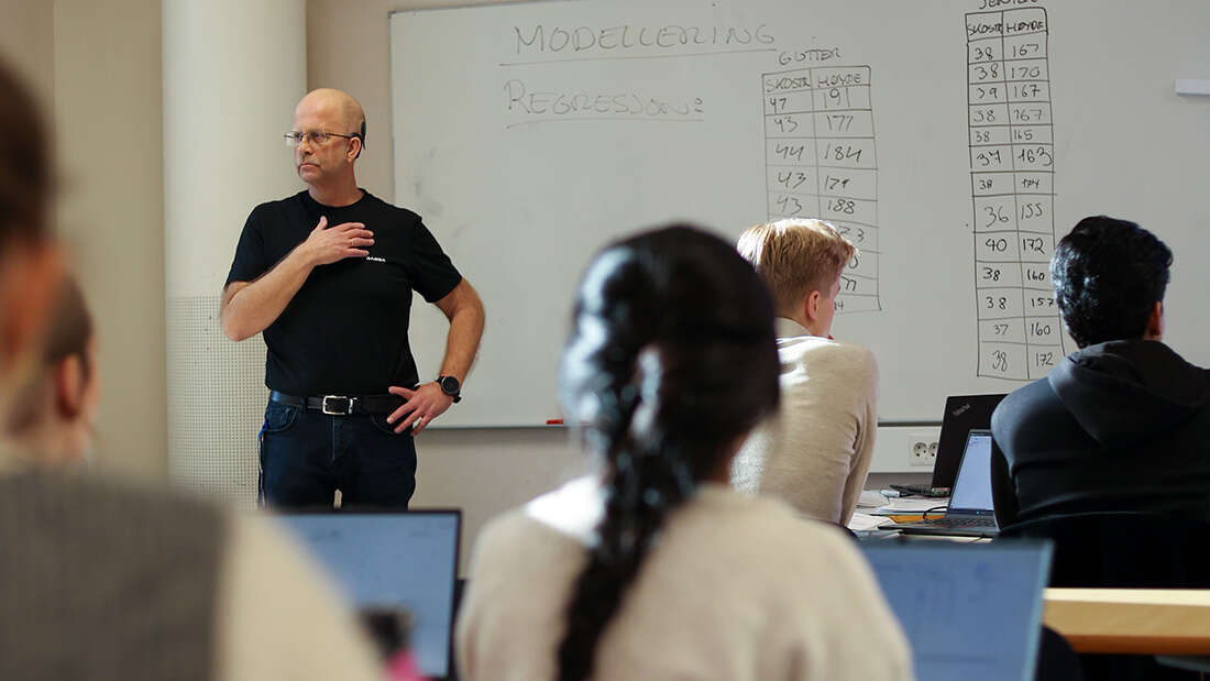 Mann som underviser elever i et klasserom.