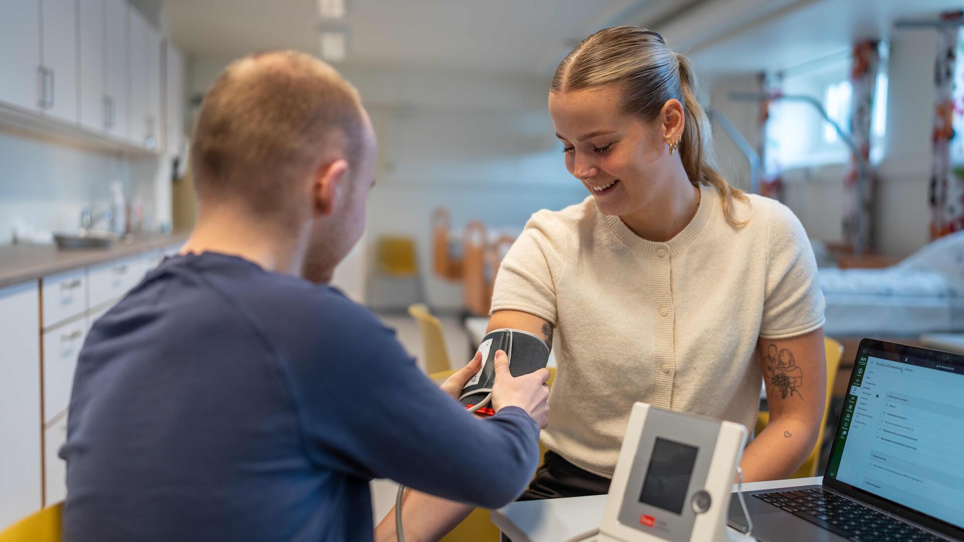 En student måler blodrtykket til en annen student.