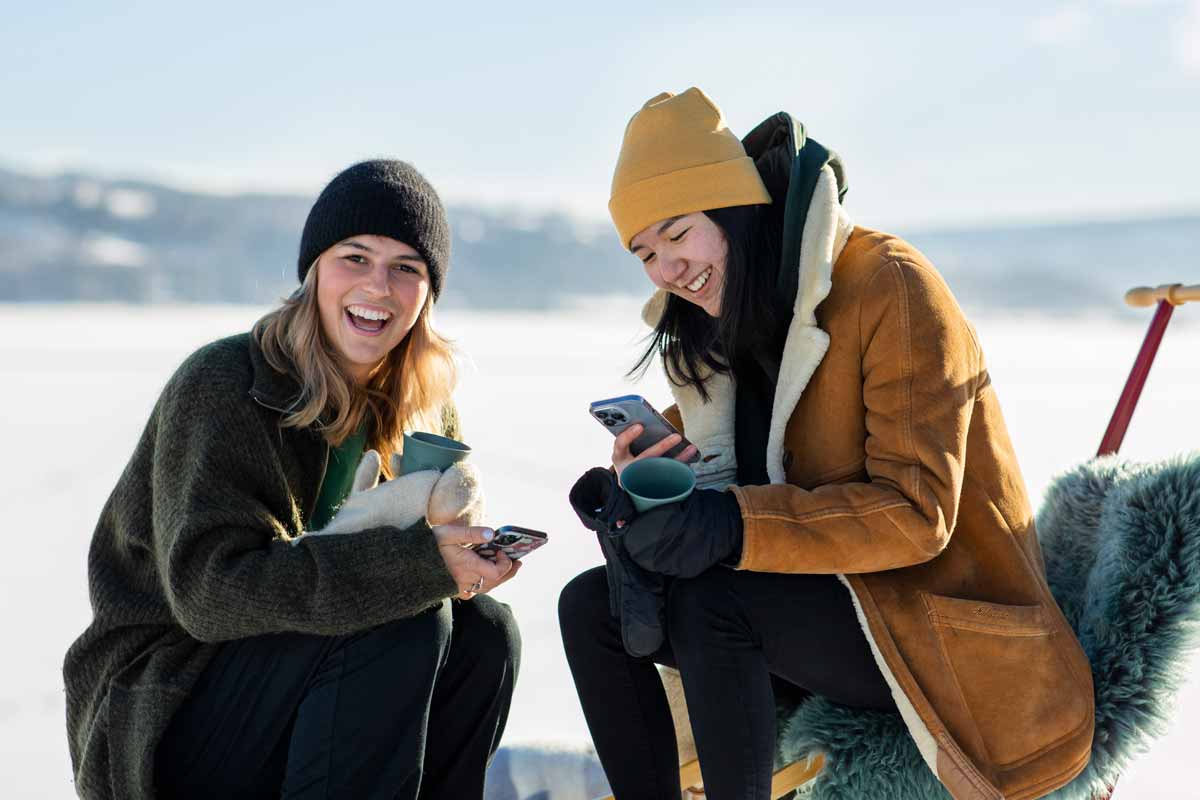 To jenter på spark med mobiltelefon