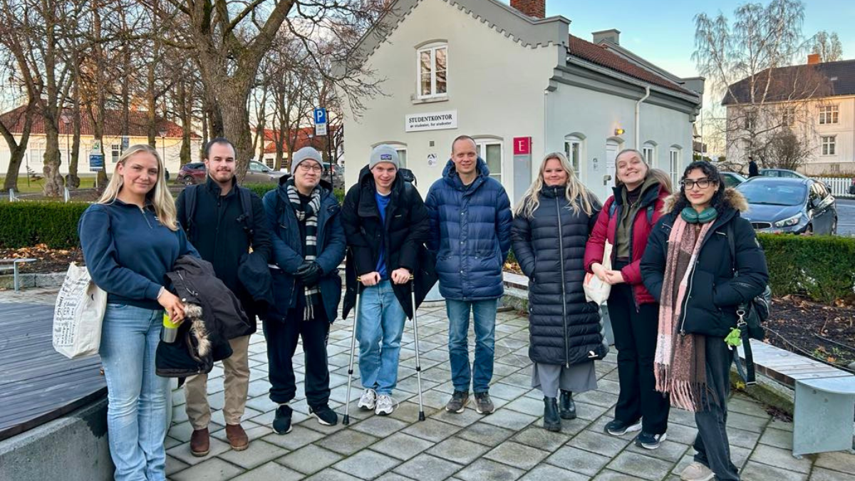 Bildet er av 8 personer som er oppsikt til kameraet utenfor studentkontoret på studiested Hamar. 