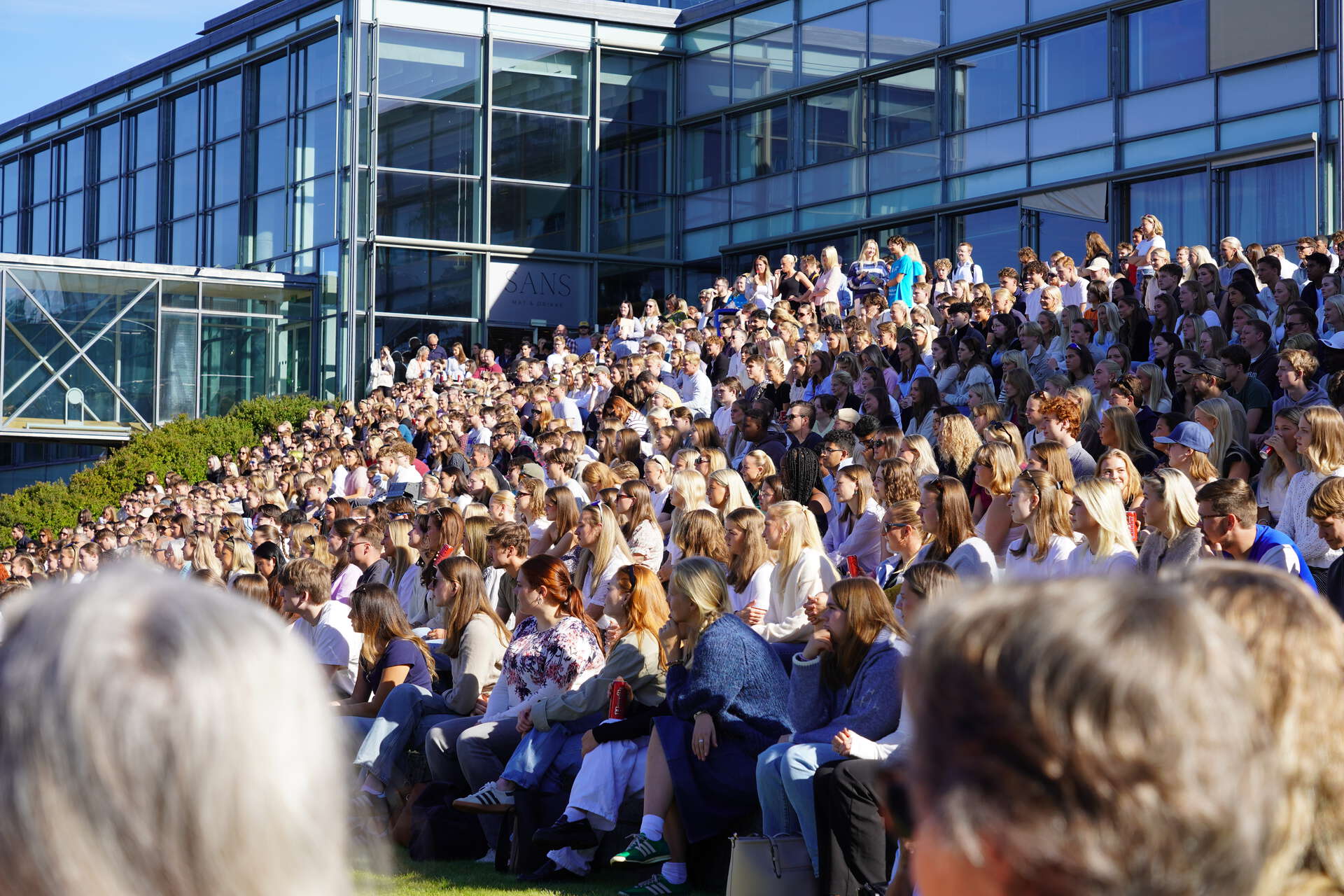 Bilde av studenter som sitter i amfiet på campus Lillehammer og følger med på åpningssermonien